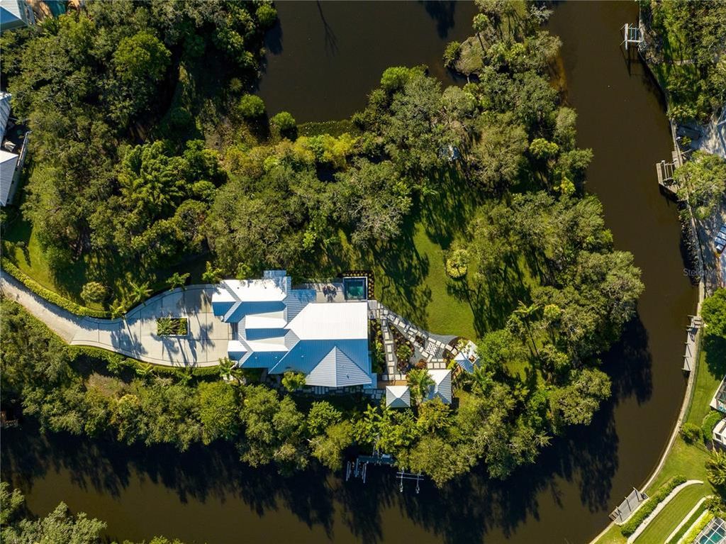 3940 Elysian Woods Lane, Sarasota, Florida is a mature landscaped estate is nestled on 1.47 acres and completely private in a small, gated community with only eight homes, was built with meticulous craftsmanship and bespoke finishes throughout.