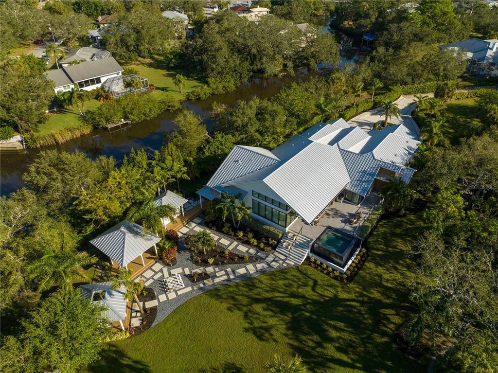 3940 Elysian Woods Lane, Sarasota, Florida is a mature landscaped estate is nestled on 1.47 acres and completely private in a small, gated community with only eight homes, was built with meticulous craftsmanship and bespoke finishes throughout.