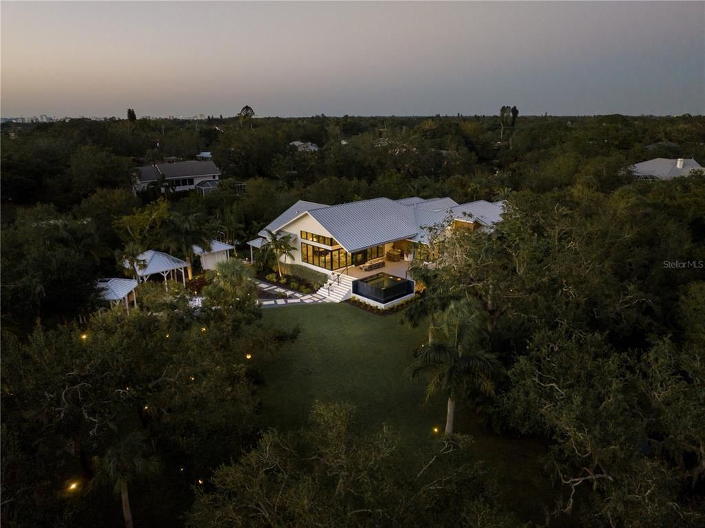3940 Elysian Woods Lane, Sarasota, Florida is a mature landscaped estate is nestled on 1.47 acres and completely private in a small, gated community with only eight homes, was built with meticulous craftsmanship and bespoke finishes throughout.