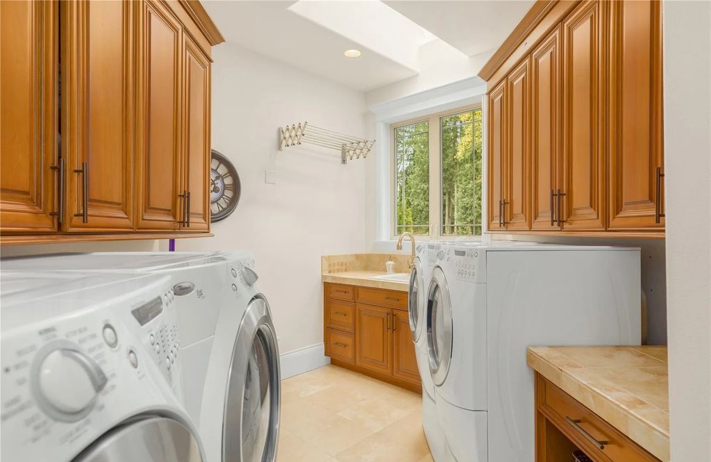 The Estate in Maple Valley boasts striking 22’ ceilings, library, home theater, gym, conference room, and an elevator to all three floors, now available for sale. This home located at 21145 212th Avenue SE, Maple Valley, Washington