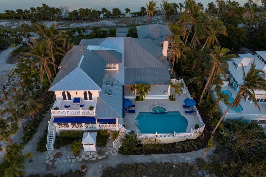 16440 Gulf Shores Drive, Boca Grande, Florida is a breathtaking home sit on unparalleled location offering privacy and luxurious coastal living with lush tropical landscaping and inviting outdoor spaces, boasting incredible views of the Gulf on one side and Lake Gasparilla on the other.