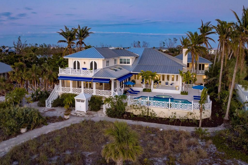 16440 Gulf Shores Drive, Boca Grande, Florida is a breathtaking home sit on unparalleled location offering privacy and luxurious coastal living with lush tropical landscaping and inviting outdoor spaces, boasting incredible views of the Gulf on one side and Lake Gasparilla on the other.