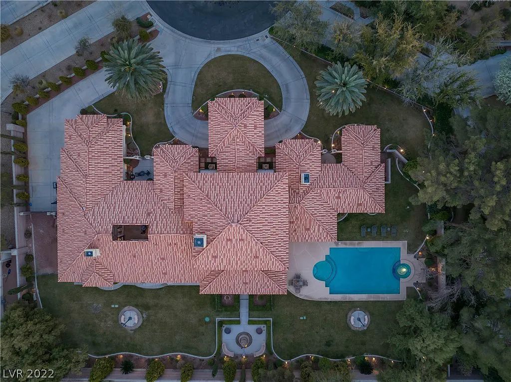 7600 Silver Meadow Court, Las Vegas, Nevada is a resort style estate in an exclusive gated enclave with a generous circular drive, a spacious living room punctuated by a stunning wrought iron floating staircase, a gourmet kitchen, venetian gardens, resort guest house and more.