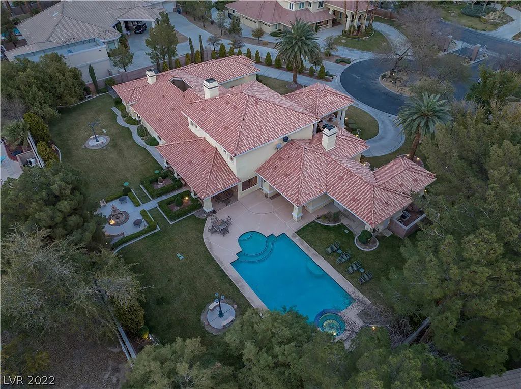 7600 Silver Meadow Court, Las Vegas, Nevada is a resort style estate in an exclusive gated enclave with a generous circular drive, a spacious living room punctuated by a stunning wrought iron floating staircase, a gourmet kitchen, venetian gardens, resort guest house and more.
