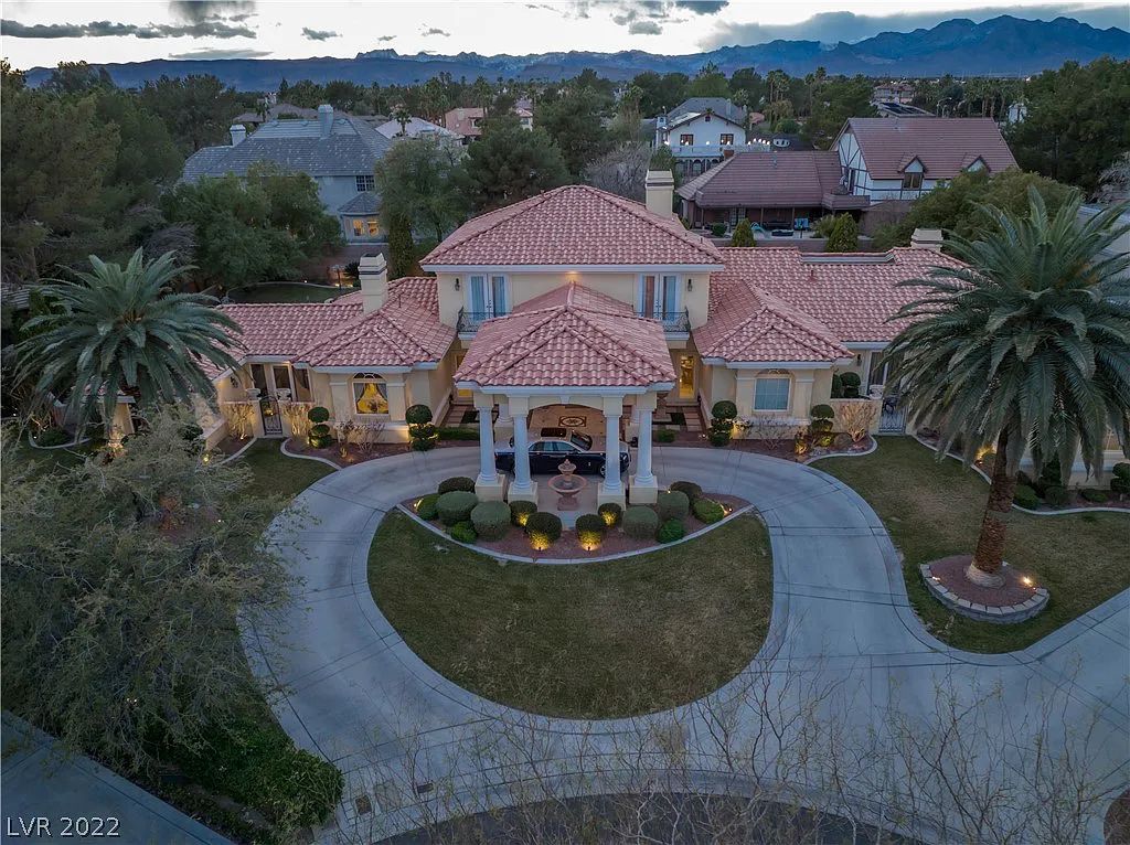 7600 Silver Meadow Court, Las Vegas, Nevada is a resort style estate in an exclusive gated enclave with a generous circular drive, a spacious living room punctuated by a stunning wrought iron floating staircase, a gourmet kitchen, venetian gardens, resort guest house and more.