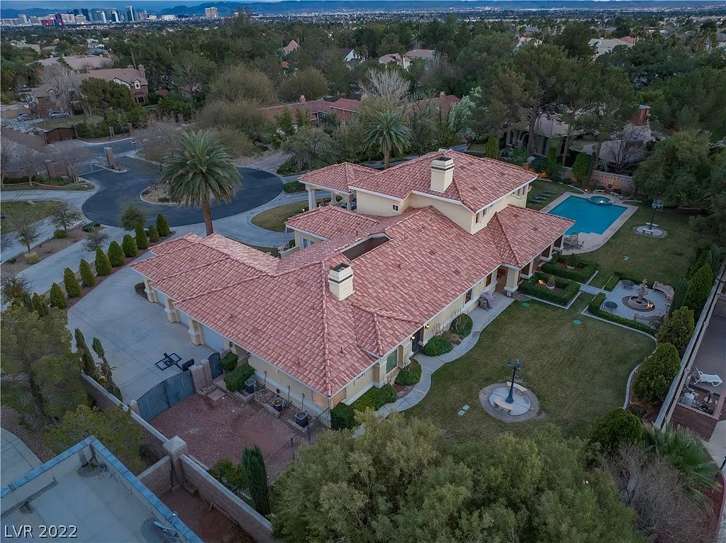 7600 Silver Meadow Court, Las Vegas, Nevada is a resort style estate in an exclusive gated enclave with a generous circular drive, a spacious living room punctuated by a stunning wrought iron floating staircase, a gourmet kitchen, venetian gardens, resort guest house and more.