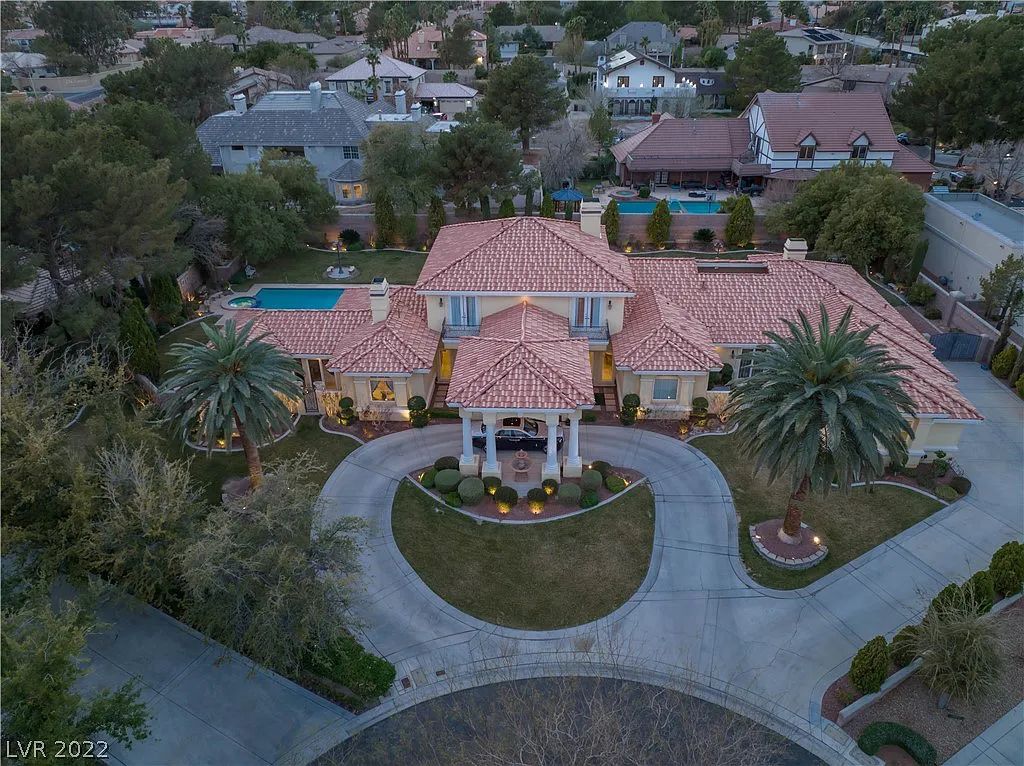 7600 Silver Meadow Court, Las Vegas, Nevada is a resort style estate in an exclusive gated enclave with a generous circular drive, a spacious living room punctuated by a stunning wrought iron floating staircase, a gourmet kitchen, venetian gardens, resort guest house and more.