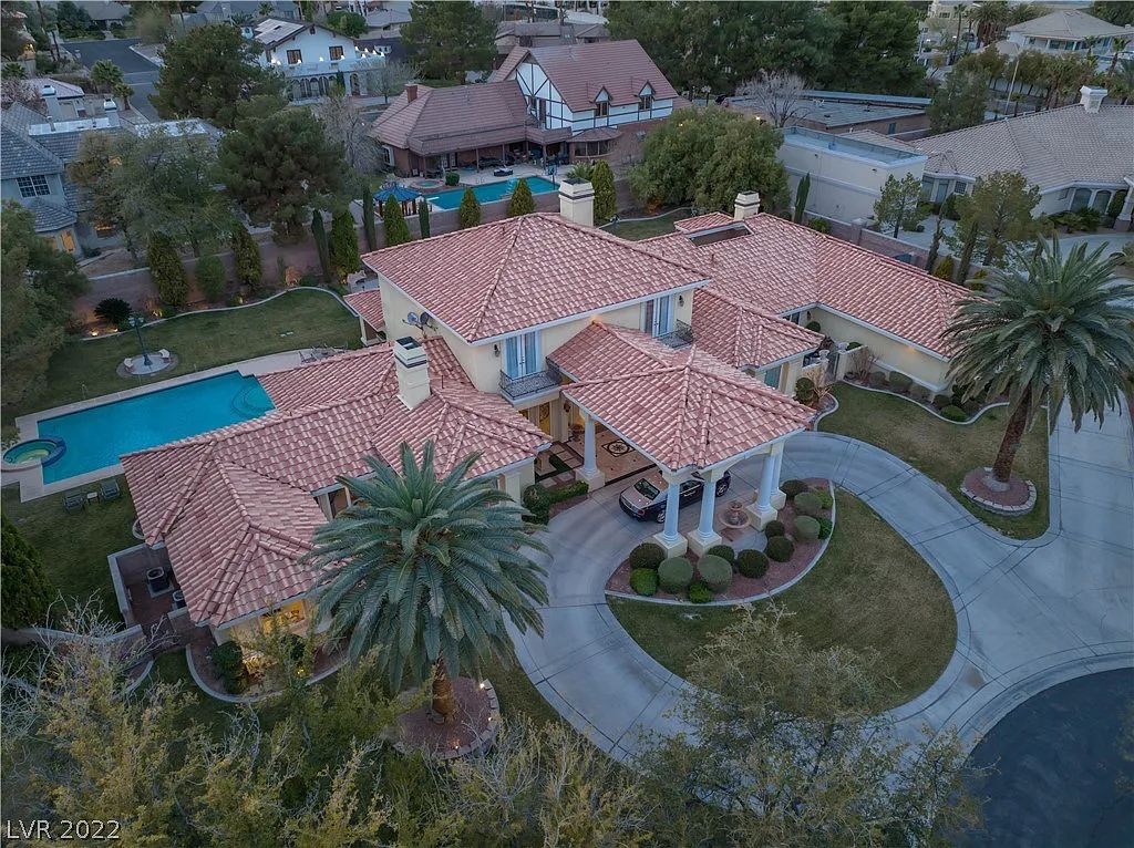 7600 Silver Meadow Court, Las Vegas, Nevada is a resort style estate in an exclusive gated enclave with a generous circular drive, a spacious living room punctuated by a stunning wrought iron floating staircase, a gourmet kitchen, venetian gardens, resort guest house and more.