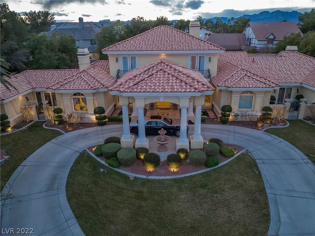 7600 Silver Meadow Court, Las Vegas, Nevada is a resort style estate in an exclusive gated enclave with a generous circular drive, a spacious living room punctuated by a stunning wrought iron floating staircase, a gourmet kitchen, venetian gardens, resort guest house and more.