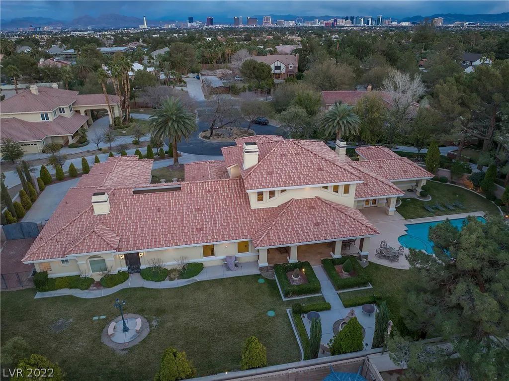 7600 Silver Meadow Court, Las Vegas, Nevada is a resort style estate in an exclusive gated enclave with a generous circular drive, a spacious living room punctuated by a stunning wrought iron floating staircase, a gourmet kitchen, venetian gardens, resort guest house and more.