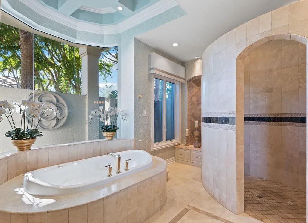 26079 Fawnwood Court, Bonita Springs, Florida, is a beautiful lakefront home built on a prominent corner lot in desirable Spring Ridge. With warm and inviting décor and a separate waterfall flowing into a tropical lagoon pool, it is a timeless design.