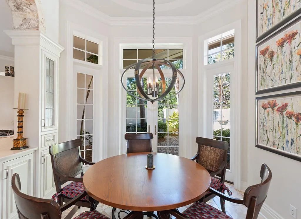 26079 Fawnwood Court, Bonita Springs, Florida, is a beautiful lakefront home built on a prominent corner lot in desirable Spring Ridge. With warm and inviting décor and a separate waterfall flowing into a tropical lagoon pool, it is a timeless design.