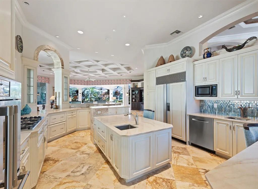 26079 Fawnwood Court, Bonita Springs, Florida, is a beautiful lakefront home built on a prominent corner lot in desirable Spring Ridge. With warm and inviting décor and a separate waterfall flowing into a tropical lagoon pool, it is a timeless design.