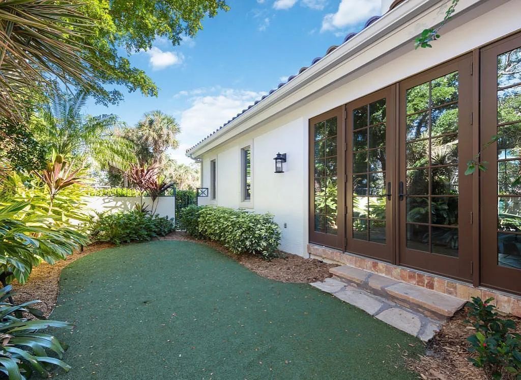 26079 Fawnwood Court, Bonita Springs, Florida, is a beautiful lakefront home built on a prominent corner lot in desirable Spring Ridge. With warm and inviting décor and a separate waterfall flowing into a tropical lagoon pool, it is a timeless design.