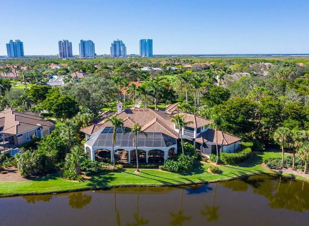 26079 Fawnwood Court, Bonita Springs, Florida, is a beautiful lakefront home built on a prominent corner lot in desirable Spring Ridge. With warm and inviting décor and a separate waterfall flowing into a tropical lagoon pool, it is a timeless design.