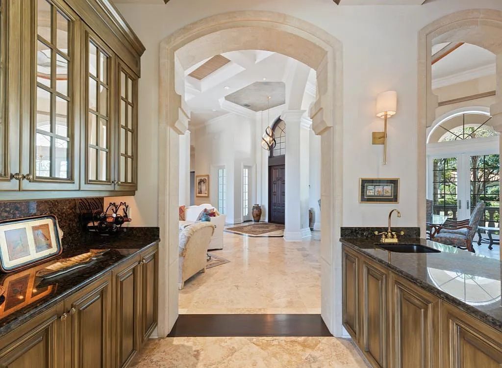 26079 Fawnwood Court, Bonita Springs, Florida, is a beautiful lakefront home built on a prominent corner lot in desirable Spring Ridge. With warm and inviting décor and a separate waterfall flowing into a tropical lagoon pool, it is a timeless design.