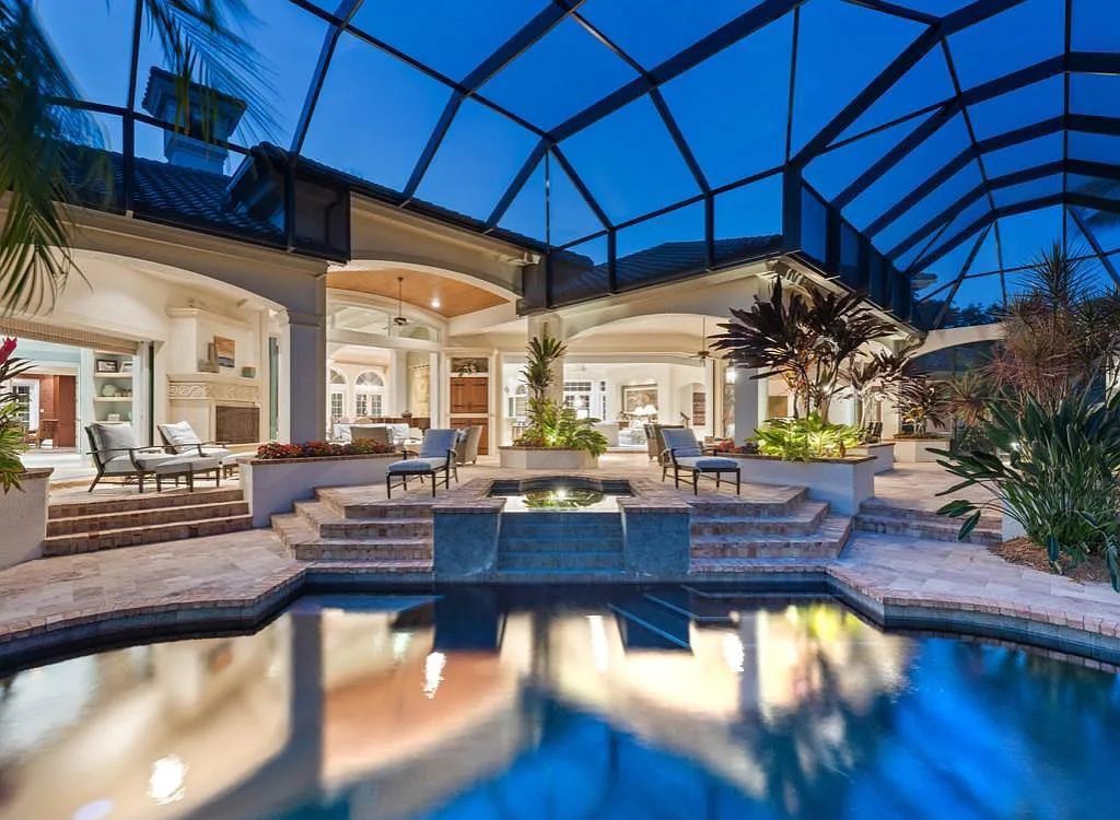 26079 Fawnwood Court, Bonita Springs, Florida, is a beautiful lakefront home built on a prominent corner lot in desirable Spring Ridge. With warm and inviting décor and a separate waterfall flowing into a tropical lagoon pool, it is a timeless design.