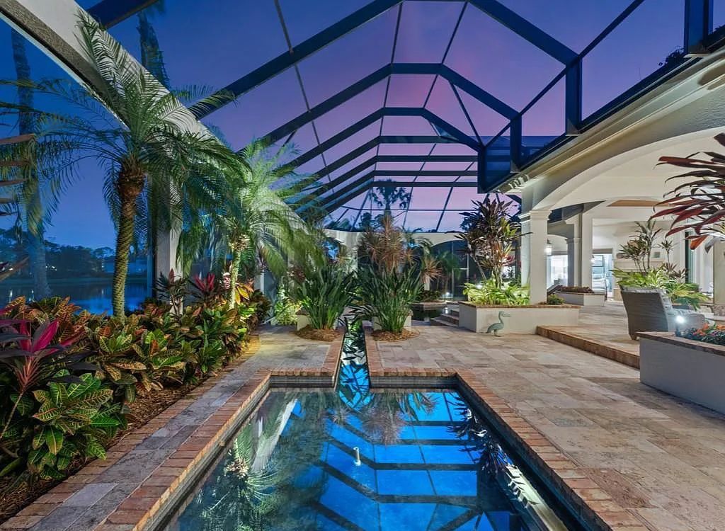 26079 Fawnwood Court, Bonita Springs, Florida, is a beautiful lakefront home built on a prominent corner lot in desirable Spring Ridge. With warm and inviting décor and a separate waterfall flowing into a tropical lagoon pool, it is a timeless design.