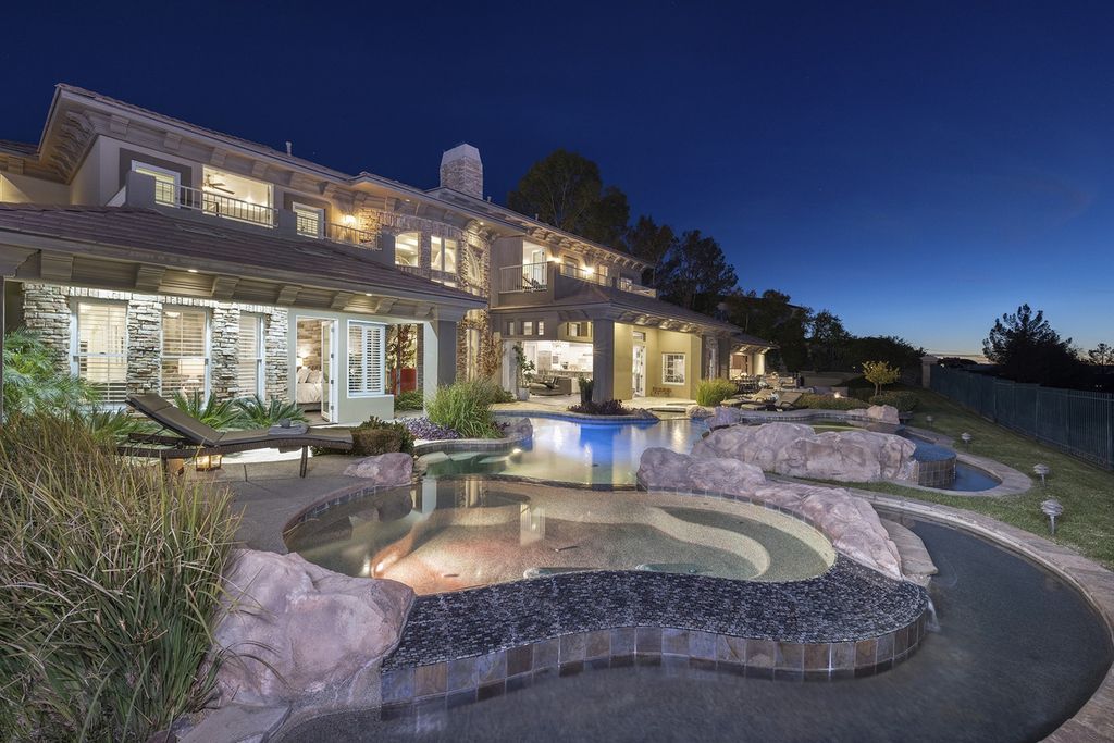 1513 Villa Rica Drive, Henderson, Nevada is a chic home in the Estates in Seven Hills with resort amenities including indoor-outdoor bar, movie theater, smart home, entertainers kitchen, bar seating, chic mirrored backsplash and more.