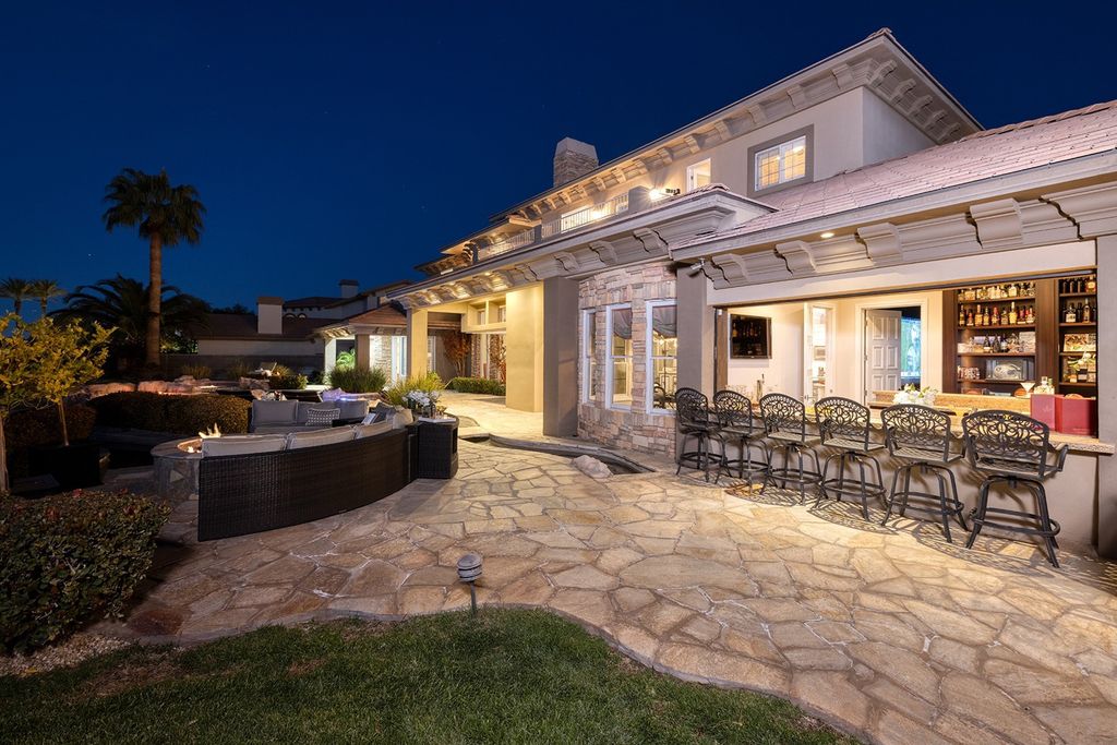 1513 Villa Rica Drive, Henderson, Nevada is a chic home in the Estates in Seven Hills with resort amenities including indoor-outdoor bar, movie theater, smart home, entertainers kitchen, bar seating, chic mirrored backsplash and more.