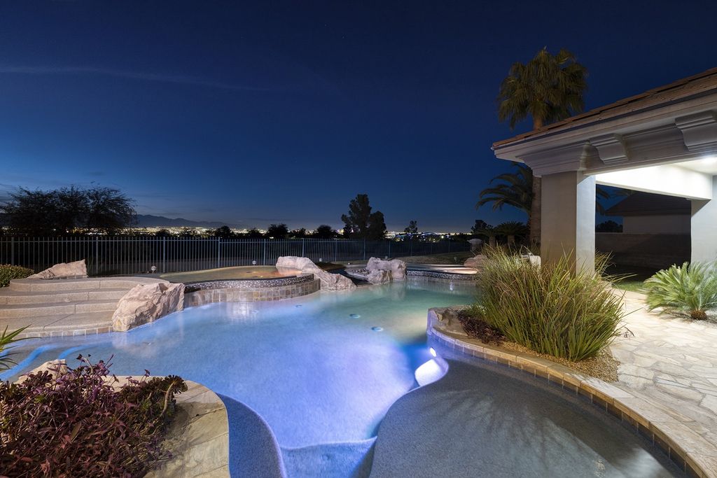 1513 Villa Rica Drive, Henderson, Nevada is a chic home in the Estates in Seven Hills with resort amenities including indoor-outdoor bar, movie theater, smart home, entertainers kitchen, bar seating, chic mirrored backsplash and more.