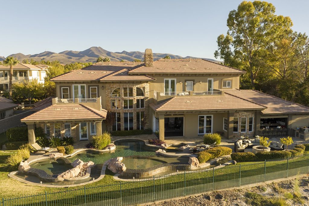 1513 Villa Rica Drive, Henderson, Nevada is a chic home in the Estates in Seven Hills with resort amenities including indoor-outdoor bar, movie theater, smart home, entertainers kitchen, bar seating, chic mirrored backsplash and more.