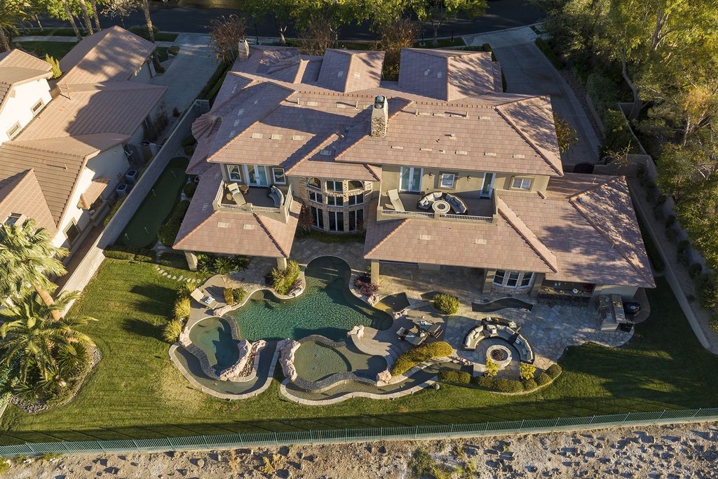 1513 Villa Rica Drive, Henderson, Nevada is a chic home in the Estates in Seven Hills with resort amenities including indoor-outdoor bar, movie theater, smart home, entertainers kitchen, bar seating, chic mirrored backsplash and more.