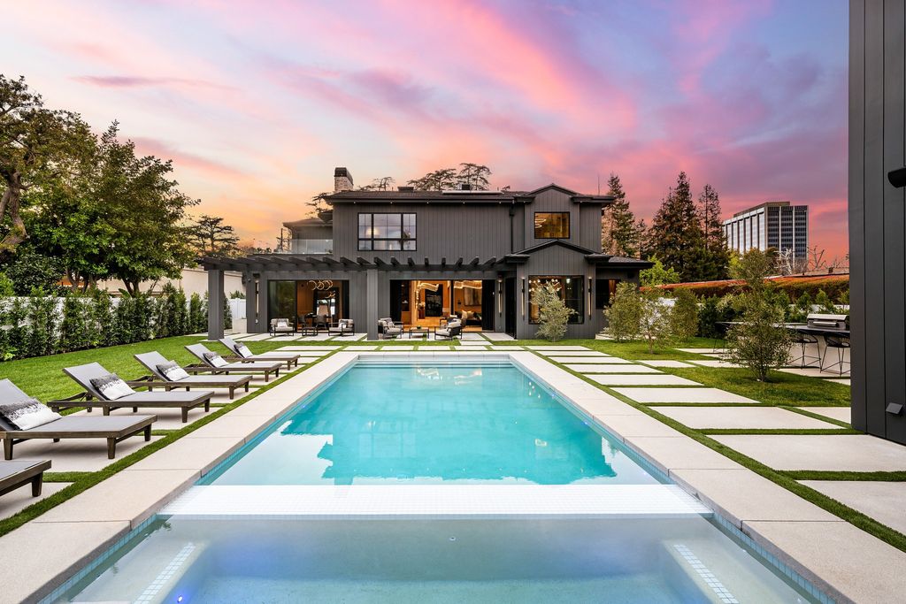 The recently built gated estate at 4508 Haskell Ave in Encino's prestigious Royal Oaks community is a true masterpiece of luxury and design. Upon entering the property, guests are welcomed by an impressive wide entry hallway with ultra-high ceilings and European oak floors. The hallway leads to the stunning living room with stone entertainment bars and a formal dining room with a fireplace and private patio.