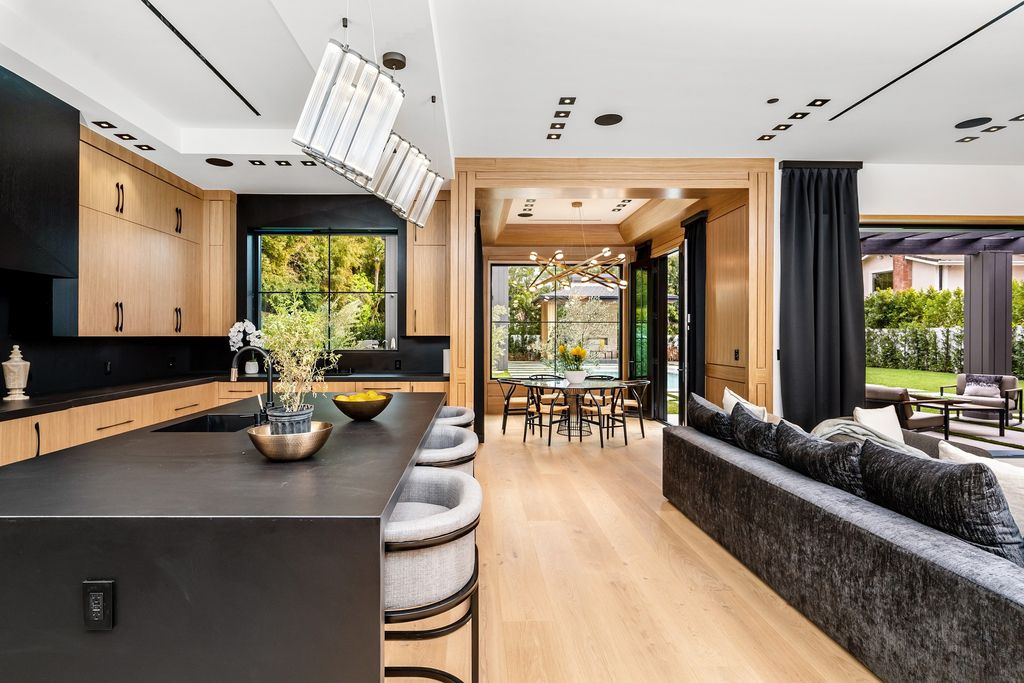 The recently built gated estate at 4508 Haskell Ave in Encino's prestigious Royal Oaks community is a true masterpiece of luxury and design. Upon entering the property, guests are welcomed by an impressive wide entry hallway with ultra-high ceilings and European oak floors. The hallway leads to the stunning living room with stone entertainment bars and a formal dining room with a fireplace and private patio.
