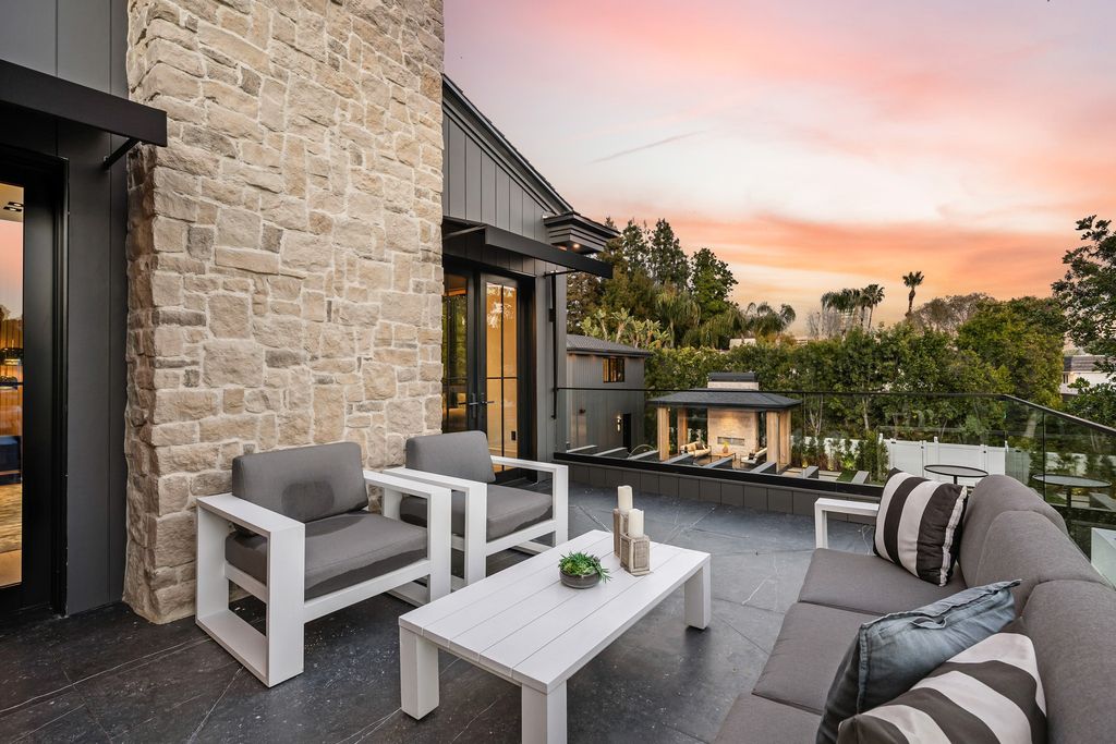 The recently built gated estate at 4508 Haskell Ave in Encino's prestigious Royal Oaks community is a true masterpiece of luxury and design. Upon entering the property, guests are welcomed by an impressive wide entry hallway with ultra-high ceilings and European oak floors. The hallway leads to the stunning living room with stone entertainment bars and a formal dining room with a fireplace and private patio.