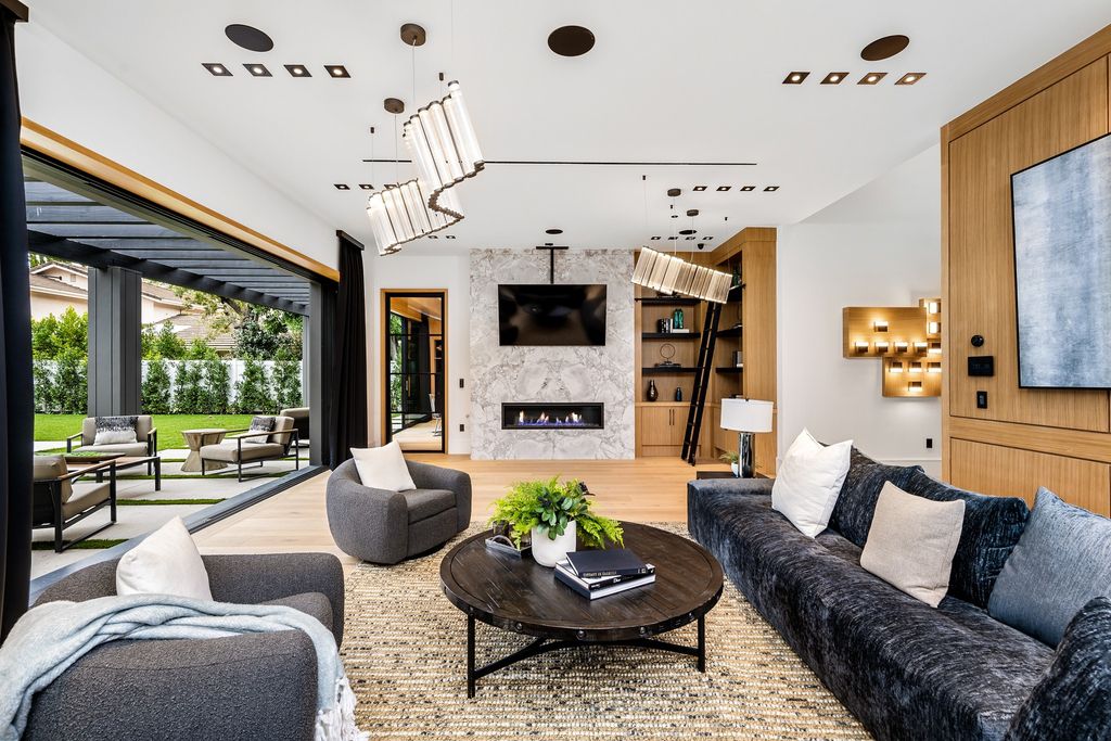 The recently built gated estate at 4508 Haskell Ave in Encino's prestigious Royal Oaks community is a true masterpiece of luxury and design. Upon entering the property, guests are welcomed by an impressive wide entry hallway with ultra-high ceilings and European oak floors. The hallway leads to the stunning living room with stone entertainment bars and a formal dining room with a fireplace and private patio.