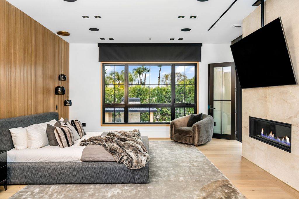 The recently built gated estate at 4508 Haskell Ave in Encino's prestigious Royal Oaks community is a true masterpiece of luxury and design. Upon entering the property, guests are welcomed by an impressive wide entry hallway with ultra-high ceilings and European oak floors. The hallway leads to the stunning living room with stone entertainment bars and a formal dining room with a fireplace and private patio.