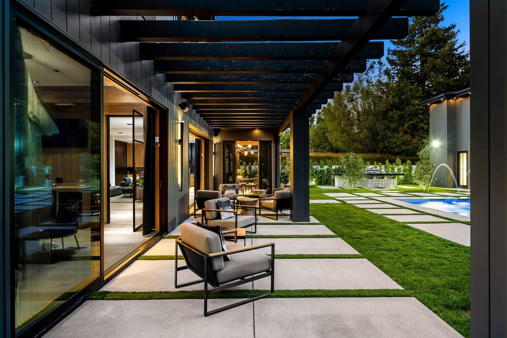The recently built gated estate at 4508 Haskell Ave in Encino's prestigious Royal Oaks community is a true masterpiece of luxury and design. Upon entering the property, guests are welcomed by an impressive wide entry hallway with ultra-high ceilings and European oak floors. The hallway leads to the stunning living room with stone entertainment bars and a formal dining room with a fireplace and private patio.
