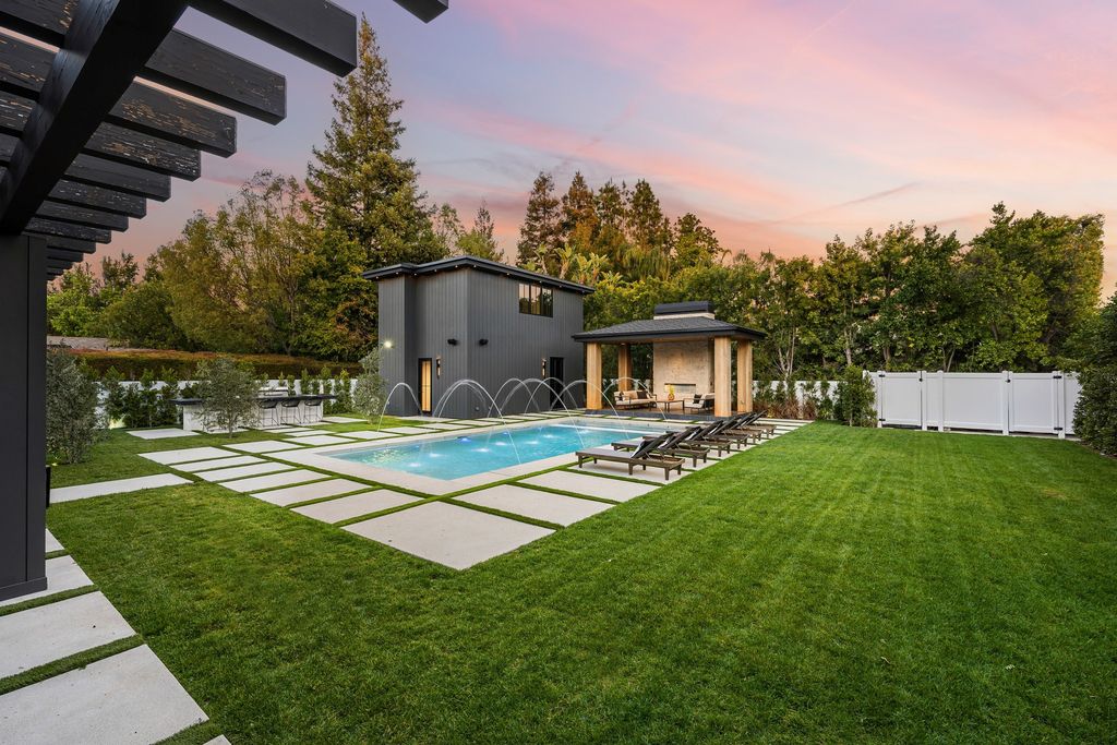 The recently built gated estate at 4508 Haskell Ave in Encino's prestigious Royal Oaks community is a true masterpiece of luxury and design. Upon entering the property, guests are welcomed by an impressive wide entry hallway with ultra-high ceilings and European oak floors. The hallway leads to the stunning living room with stone entertainment bars and a formal dining room with a fireplace and private patio.