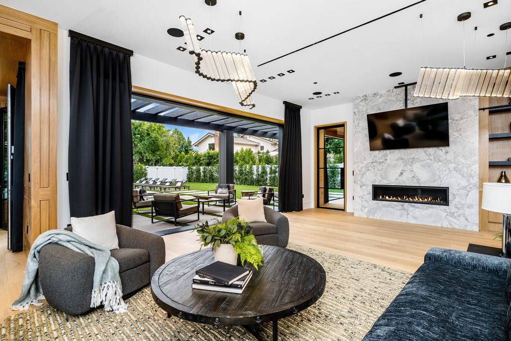 The recently built gated estate at 4508 Haskell Ave in Encino's prestigious Royal Oaks community is a true masterpiece of luxury and design. Upon entering the property, guests are welcomed by an impressive wide entry hallway with ultra-high ceilings and European oak floors. The hallway leads to the stunning living room with stone entertainment bars and a formal dining room with a fireplace and private patio.