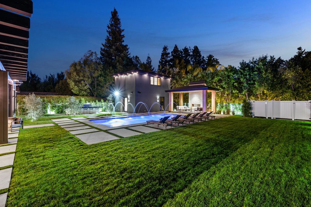 The recently built gated estate at 4508 Haskell Ave in Encino's prestigious Royal Oaks community is a true masterpiece of luxury and design. Upon entering the property, guests are welcomed by an impressive wide entry hallway with ultra-high ceilings and European oak floors. The hallway leads to the stunning living room with stone entertainment bars and a formal dining room with a fireplace and private patio.