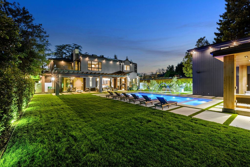 The recently built gated estate at 4508 Haskell Ave in Encino's prestigious Royal Oaks community is a true masterpiece of luxury and design. Upon entering the property, guests are welcomed by an impressive wide entry hallway with ultra-high ceilings and European oak floors. The hallway leads to the stunning living room with stone entertainment bars and a formal dining room with a fireplace and private patio.