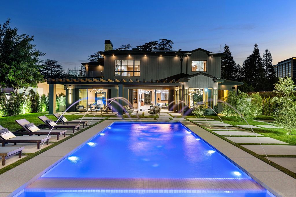 The recently built gated estate at 4508 Haskell Ave in Encino's prestigious Royal Oaks community is a true masterpiece of luxury and design. Upon entering the property, guests are welcomed by an impressive wide entry hallway with ultra-high ceilings and European oak floors. The hallway leads to the stunning living room with stone entertainment bars and a formal dining room with a fireplace and private patio.