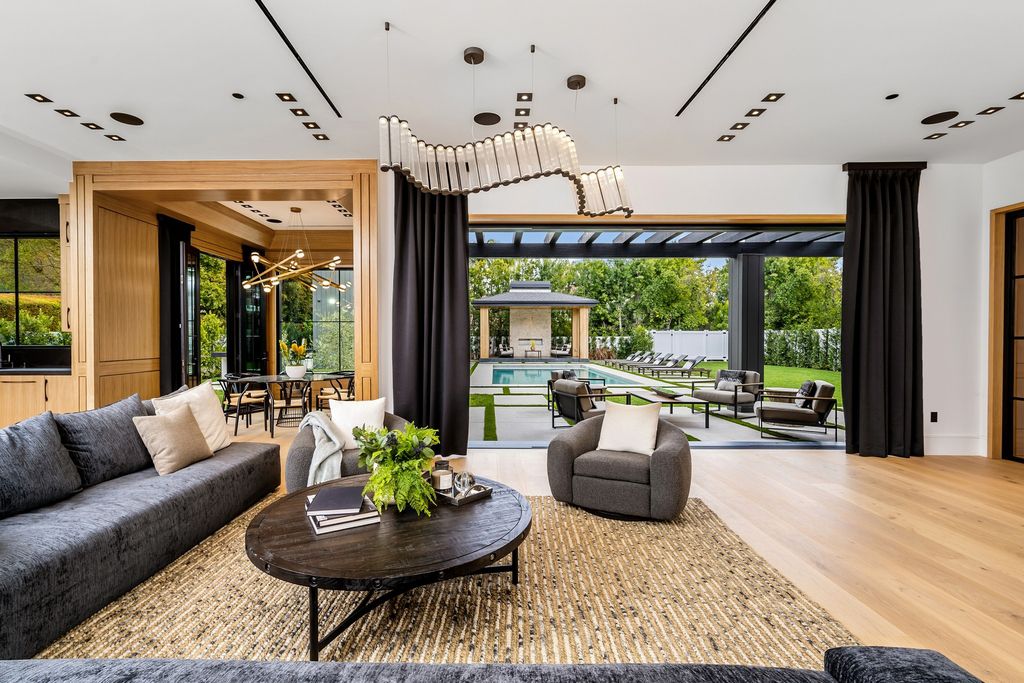 The recently built gated estate at 4508 Haskell Ave in Encino's prestigious Royal Oaks community is a true masterpiece of luxury and design. Upon entering the property, guests are welcomed by an impressive wide entry hallway with ultra-high ceilings and European oak floors. The hallway leads to the stunning living room with stone entertainment bars and a formal dining room with a fireplace and private patio.