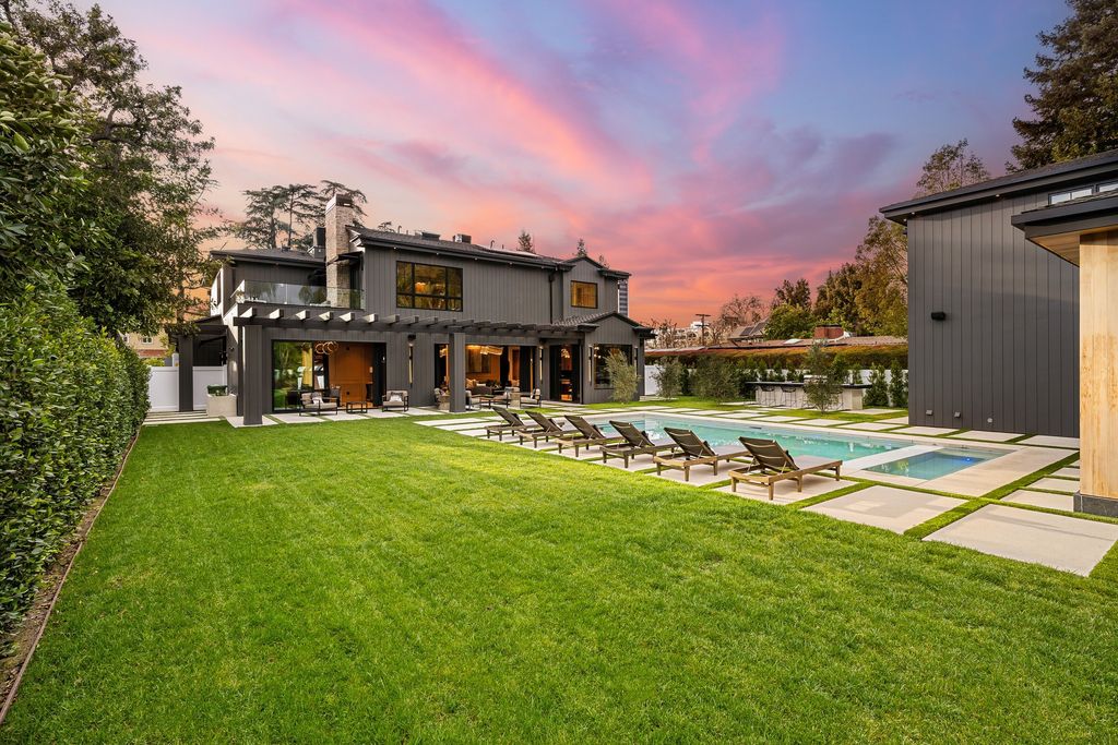 The recently built gated estate at 4508 Haskell Ave in Encino's prestigious Royal Oaks community is a true masterpiece of luxury and design. Upon entering the property, guests are welcomed by an impressive wide entry hallway with ultra-high ceilings and European oak floors. The hallway leads to the stunning living room with stone entertainment bars and a formal dining room with a fireplace and private patio.