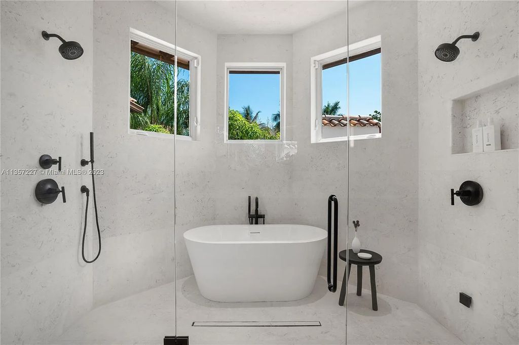 This stunning waterfront home is located at 152 Paloma Drive in the exclusive gated community of Islands of Cocoplum in Coral Gables, Florida. It features 6 bedrooms, 5.5 bathrooms, a brand new kitchen with top-of-the-line appliances, impact windows throughout, and a fabulous custom bar.