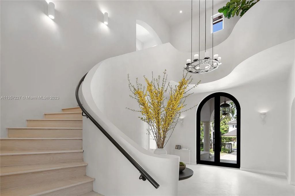 This stunning waterfront home is located at 152 Paloma Drive in the exclusive gated community of Islands of Cocoplum in Coral Gables, Florida. It features 6 bedrooms, 5.5 bathrooms, a brand new kitchen with top-of-the-line appliances, impact windows throughout, and a fabulous custom bar.