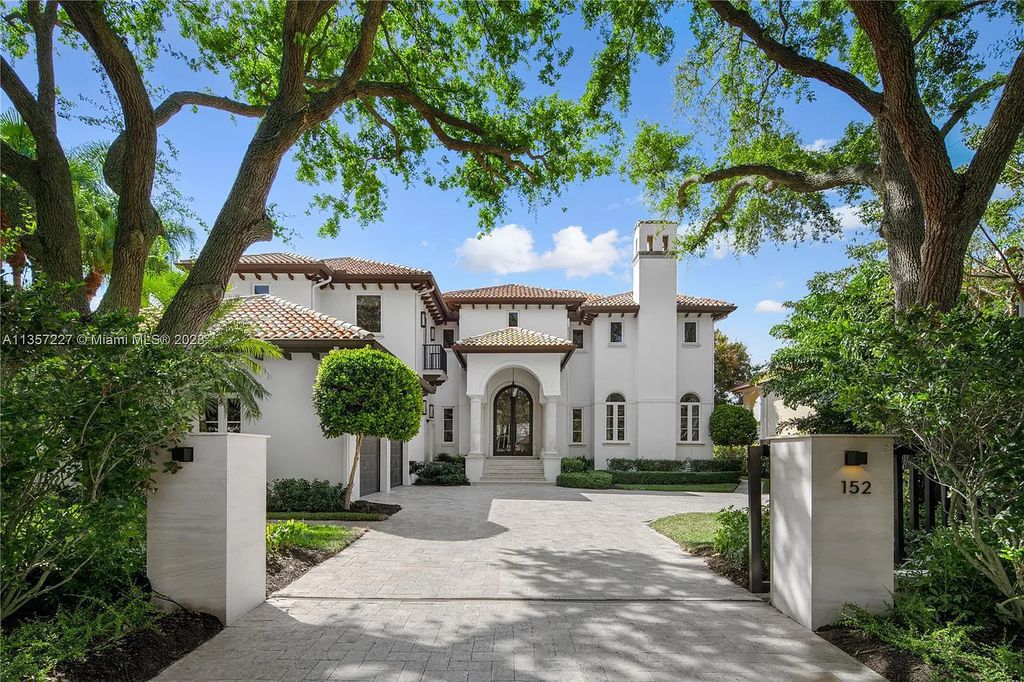 This stunning waterfront home is located at 152 Paloma Drive in the exclusive gated community of Islands of Cocoplum in Coral Gables, Florida. It features 6 bedrooms, 5.5 bathrooms, a brand new kitchen with top-of-the-line appliances, impact windows throughout, and a fabulous custom bar.