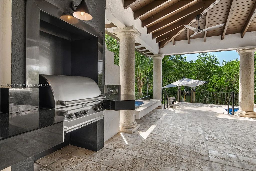 This stunning waterfront home is located at 152 Paloma Drive in the exclusive gated community of Islands of Cocoplum in Coral Gables, Florida. It features 6 bedrooms, 5.5 bathrooms, a brand new kitchen with top-of-the-line appliances, impact windows throughout, and a fabulous custom bar.