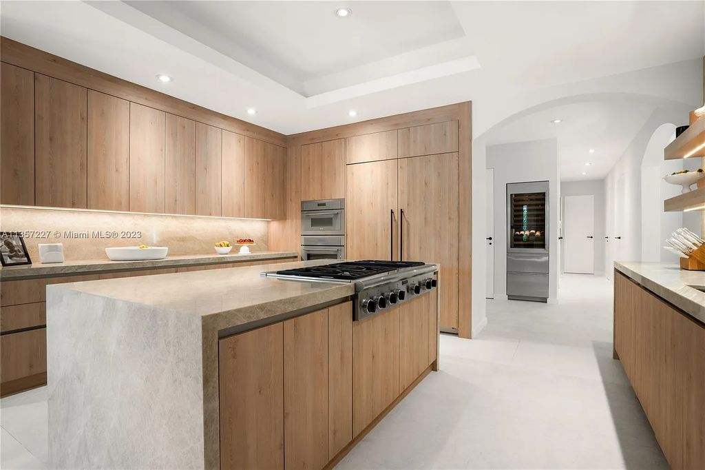 This stunning waterfront home is located at 152 Paloma Drive in the exclusive gated community of Islands of Cocoplum in Coral Gables, Florida. It features 6 bedrooms, 5.5 bathrooms, a brand new kitchen with top-of-the-line appliances, impact windows throughout, and a fabulous custom bar.