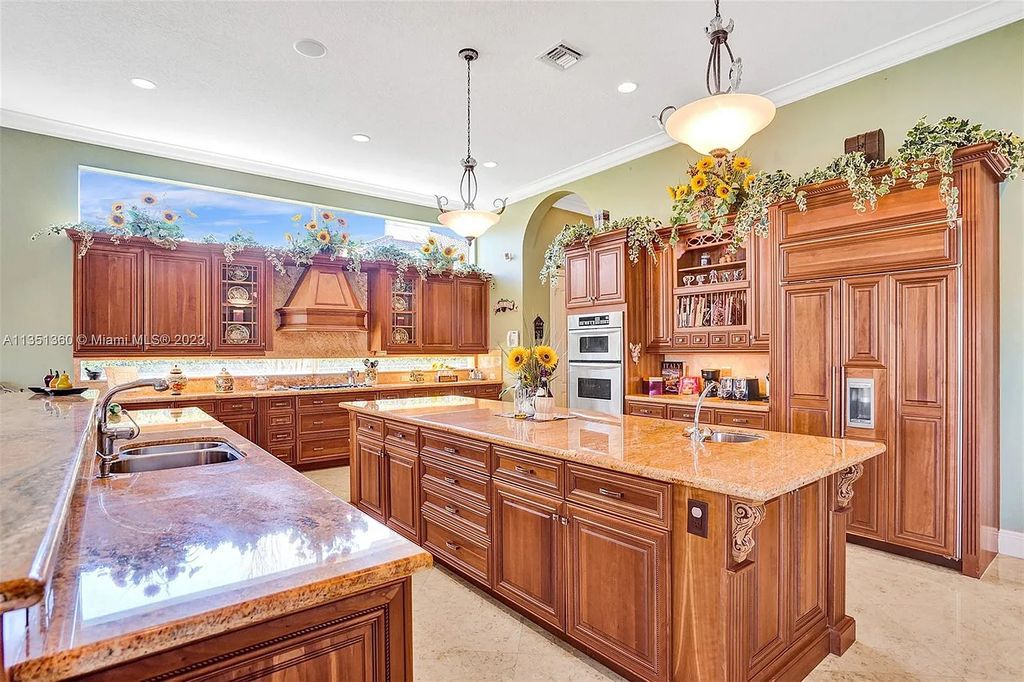 3308 Islewood Avenue, Weston, Florida is located in the prestigious gated community of Windmill Reserve, and it offers luxurious living on a grand scale. Situated on a premium lake lot with a lushly landscaped yard, this home in Weston features a gas-heated pool/spa, covered summer kitchen, Chicago brick patio, and roll-down shades, making it perfect for entertaining guests or enjoying time with family.