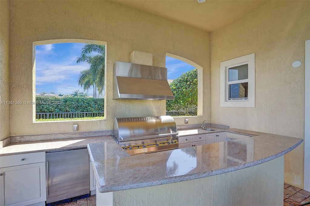 3308 Islewood Avenue, Weston, Florida is located in the prestigious gated community of Windmill Reserve, and it offers luxurious living on a grand scale. Situated on a premium lake lot with a lushly landscaped yard, this home in Weston features a gas-heated pool/spa, covered summer kitchen, Chicago brick patio, and roll-down shades, making it perfect for entertaining guests or enjoying time with family.