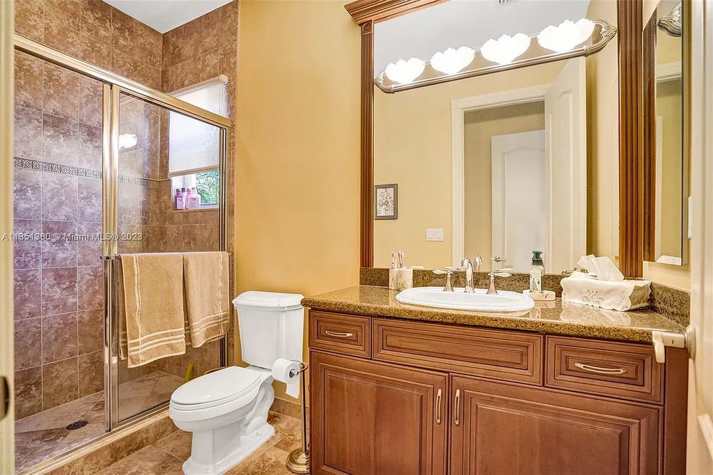 3308 Islewood Avenue, Weston, Florida is located in the prestigious gated community of Windmill Reserve, and it offers luxurious living on a grand scale. Situated on a premium lake lot with a lushly landscaped yard, this home in Weston features a gas-heated pool/spa, covered summer kitchen, Chicago brick patio, and roll-down shades, making it perfect for entertaining guests or enjoying time with family.