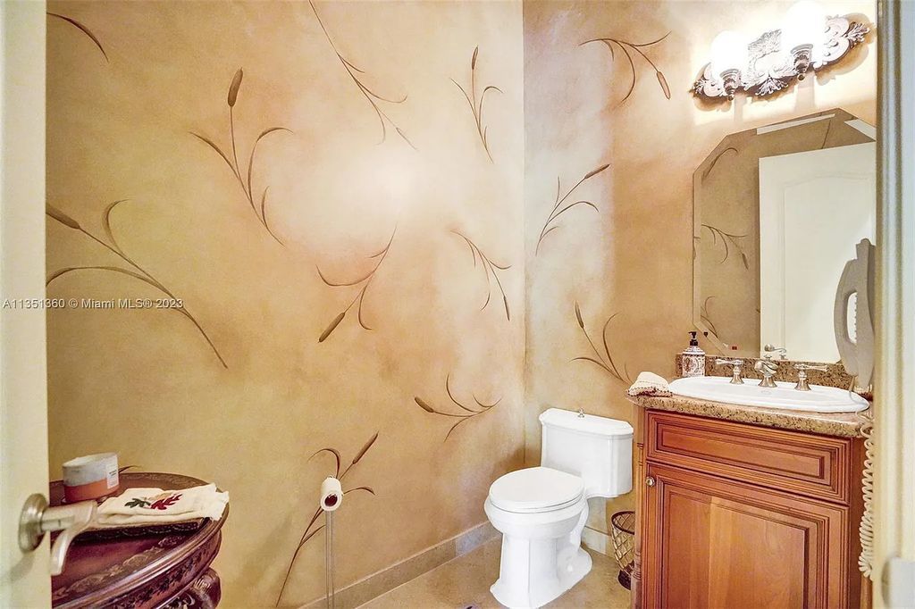 3308 Islewood Avenue, Weston, Florida is located in the prestigious gated community of Windmill Reserve, and it offers luxurious living on a grand scale. Situated on a premium lake lot with a lushly landscaped yard, this home in Weston features a gas-heated pool/spa, covered summer kitchen, Chicago brick patio, and roll-down shades, making it perfect for entertaining guests or enjoying time with family.