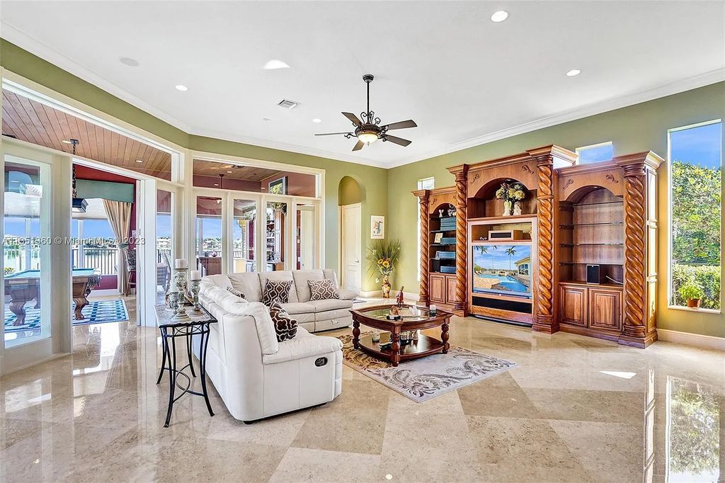 3308 Islewood Avenue, Weston, Florida is located in the prestigious gated community of Windmill Reserve, and it offers luxurious living on a grand scale. Situated on a premium lake lot with a lushly landscaped yard, this home in Weston features a gas-heated pool/spa, covered summer kitchen, Chicago brick patio, and roll-down shades, making it perfect for entertaining guests or enjoying time with family.